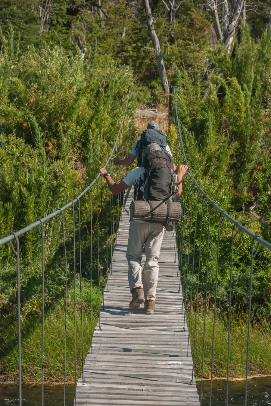 Dos personas cruzando un puente colgante en la Patagonia